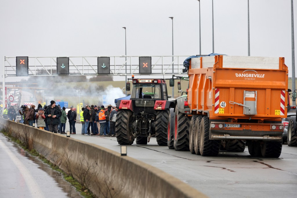 Farmers use tractors to block the A29 motorway at Boves near Amiens, northern France on January 23, 2024, as they stage a protest against taxation and falling incomes. France's powerful agricultural unions met the French Prime Minister on January 22, after threatening the government with a week or more of protest actions if their demands were not met. The unions have demanded concrete action from the government to address their grievances, which they say include excessive financial burdens and environmental protection rules as well as insufficient prices for their products. (Photo by Denis Charlet / AFP)