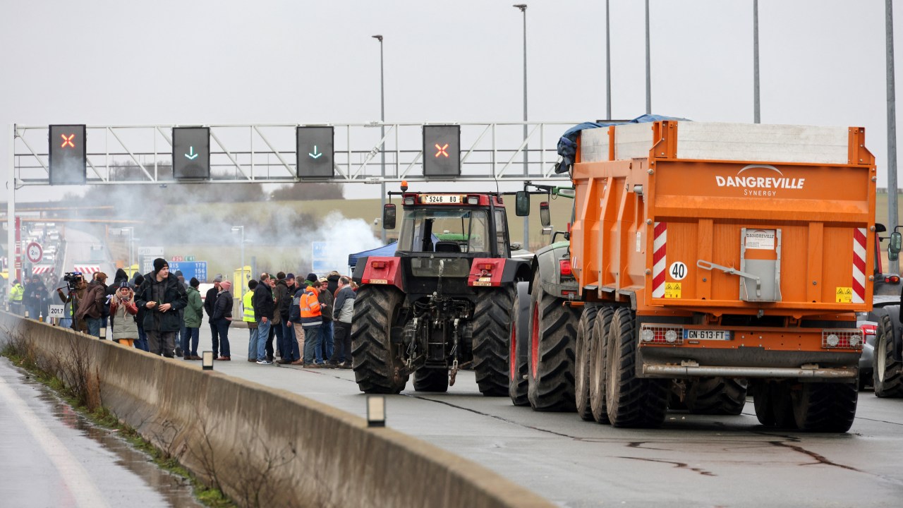 Farmers use tractors to block the A29 motorway at Boves near Amiens, northern France on January 23, 2024, as they stage a protest against taxation and falling incomes. France's powerful agricultural unions met the French Prime Minister on January 22, after threatening the government with a week or more of protest actions if their demands were not met. The unions have demanded concrete action from the government to address their grievances, which they say include excessive financial burdens and environmental protection rules as well as insufficient prices for their products. (Photo by Denis Charlet / AFP)