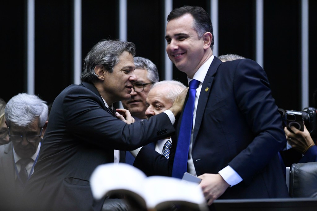 Haddad cumprimenta Pacheco no plenário do Senado, com Lula ao fundo