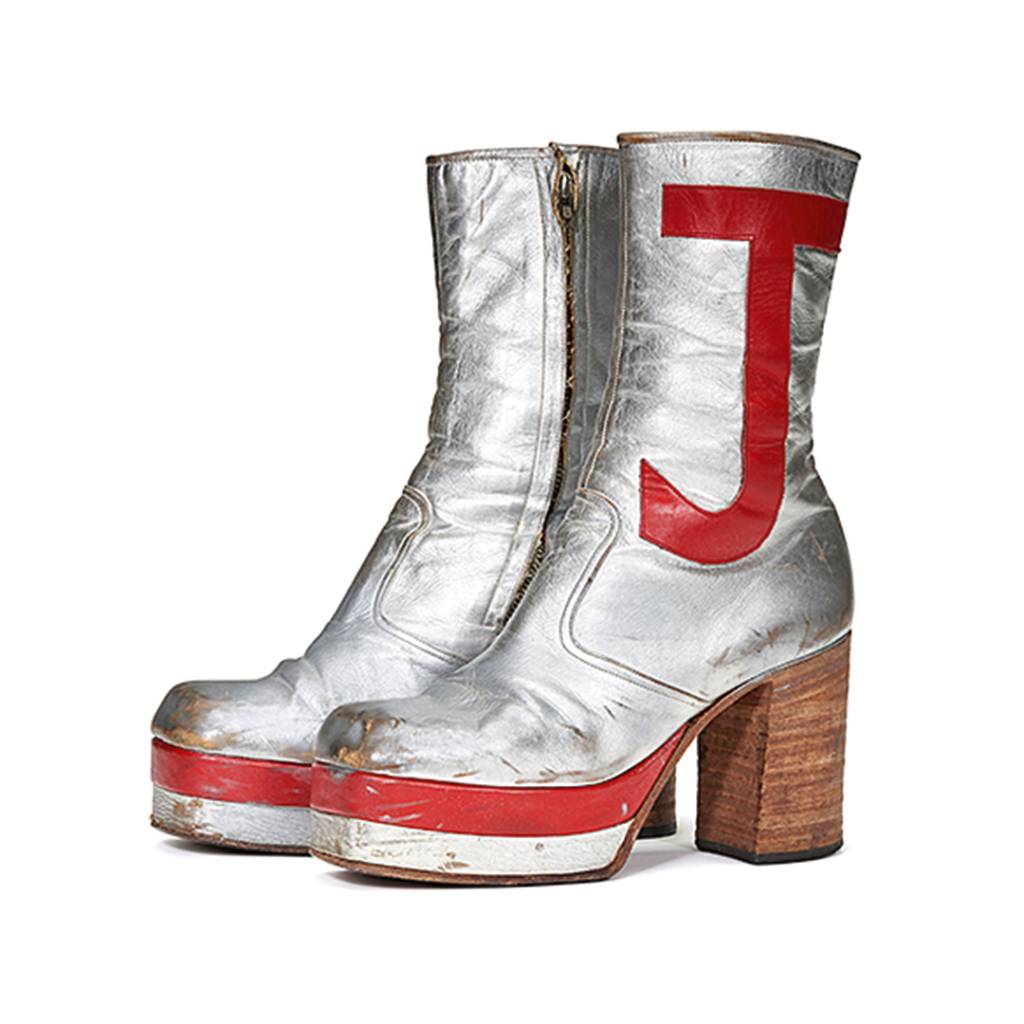 A-PAIR-OF-SILVER-LEATHER-TALL-PLATFORM-BOOTS,-CIRCA-1971.jpg PISADA FIRME - O par de botas plataforma, com as letras do nome do gênio pop: lance inicial de 5 000 dólares