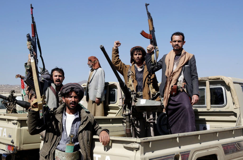SANA'A, YEMEN - JANUARY 14: Houthi followers lift rifles and shout slogans against the U.S.-U.K. during a tribal gathering on January 14, 2024 on the outskirts of Sana'a, Yemen. Houthi followers gathered to protest against the U.S.-U.K. airstrikes on positions in areas under their control. (Photo by Mohammed Hamoud/Getty Images)