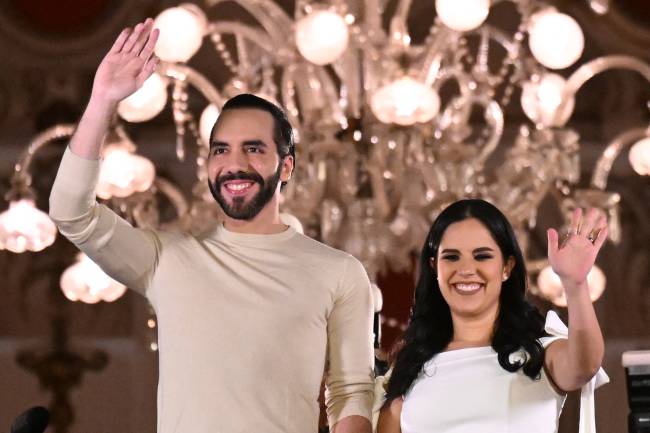 Salvadoran President Nayib Bukele greets supporters next to his wife Gabriela Rodriguez after the presidential and legislative elections in San Salvador on February 4, 2024. Fireworks erupted in El Salvador's capital as gang-busting President Nayib Bukele claimed to have won reelection with more than 85 percent of votes cast: 
