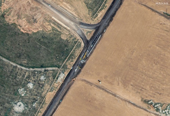 This handout satellite picture taken and released by Maxar Technologies on February 15, 2024 shows machinery building a wall along the Egypt-Gaza Strip border in Rafah, Egypt. Hundreds of thousands of displaced Palestinians have been driven into Gaza's southernmost city by Israel's relentless military campaign, seeking shelter in a sprawling makeshift encampment near the Egypt border. (Photo by Handout / Satellite image ©2024 Maxar Technologies / AFP) / RESTRICTED TO EDITORIAL USE - MANDATORY CREDIT 
