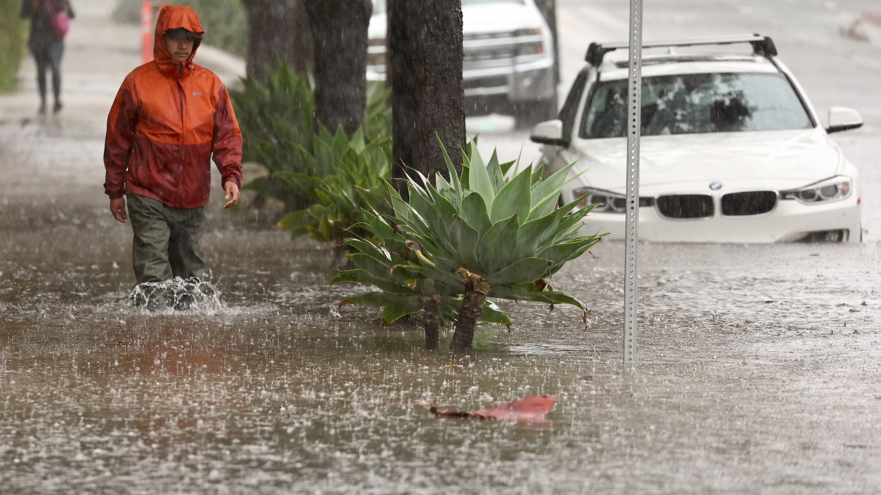 SANTA BARBARA, CALIFORNIA - FEBRUARY 04: A person walks through flood waters as a powerful long-duration atmospheric river storm, the second in less than a week, impacts California on February 4, 2024 in Santa Barbara, California. The storm is delivering potential for widespread flooding, landslides and power outages while dropping heavy rain and snow across the region. Mario Tama/Getty Images/AFP (Photo by MARIO TAMA / GETTY IMAGES NORTH AMERICA / Getty Images via AFP)