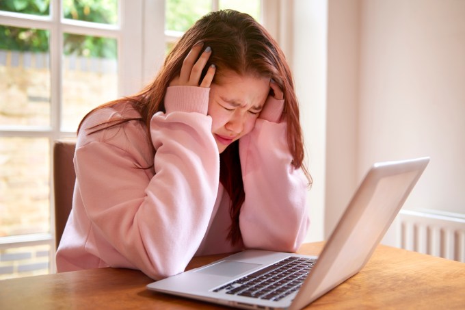 Teenager crying using laptop
