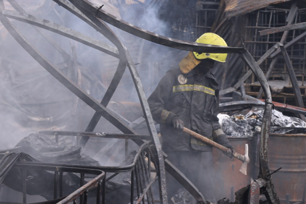 Um bombeiro tenta apagar incêndio que destruiu casas, armazéns e outras instalações na cidade de Nairobi, no Quênia. 31/01/2024