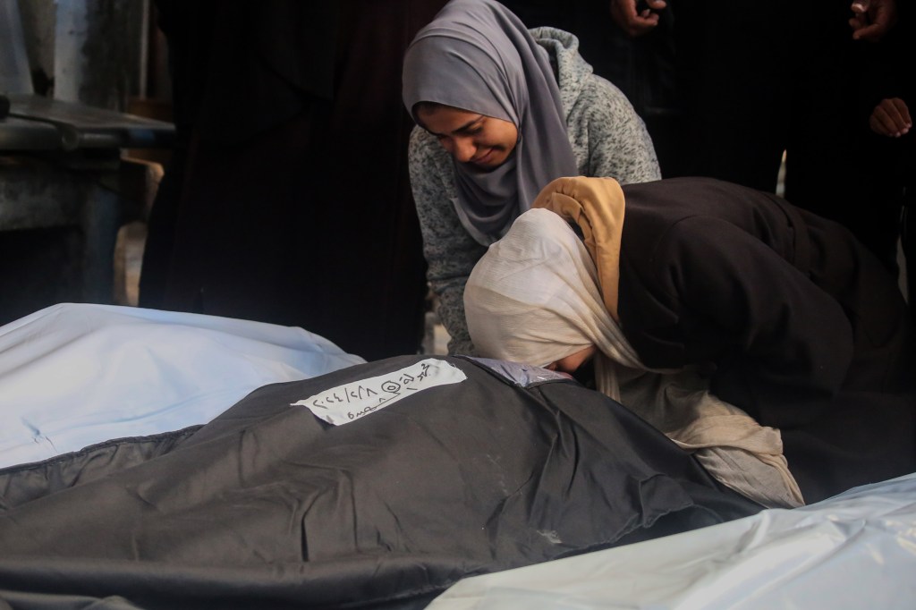 Pessoas choram ao receber os cadáveres das vítimas de um ataque israelense a Rafah, na Faixa de Gaza. 08/02/2023