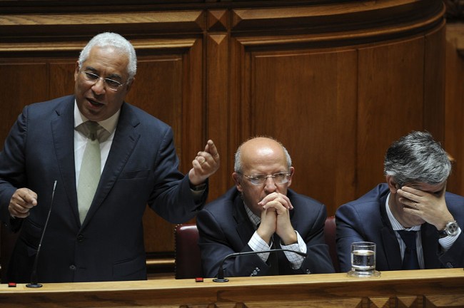 Antonio Costa, Portugal's prime minister, left, speaks as Augusto Santos Silva, Portugal's foreign minister, center, and Mario Centeno, Portugal's finance minister, listen during the state-of-the-nation debate at parliament in Lisbon, Portugal, on Thursday, July 7, 2016. Spain and Portugal were hit by a European Union move to fine them for breaching budget deficit limits in an unprecedented step to enforce rules designed to avert another debt crisis. Photographer: Paulo Duarte/Bloomberg via Getty Images
