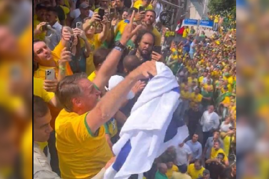 O ex-presidente Jair Bolsonaro (PL) levanta uma bandeira de Israel para apoiadores durante manifestação na Avenida Paulista, em São Paulo, em 25 de fevereiro de 2024