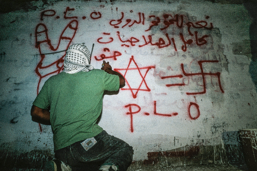 Palestino grafita contra Israel em muro na Cisjordânia