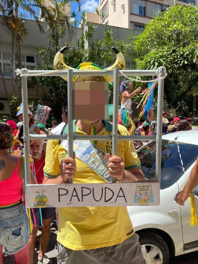 Folião usa fantasia de "Patriota da Papuda" em alusão a participantes do atentado golpista do 8 de Janeiro presos em Brasília