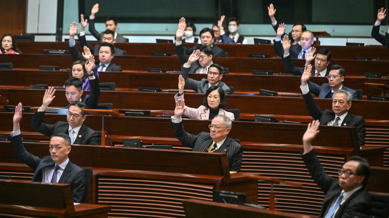 Lawmakers vote for Article 23 in the chamber of the Legislative Council after the conclusion of the readings of the Article 23 National Security Law, in Hong Kong on March 19, 2024. Hong Kong's legislature unanimously passed a new national security law on March 19, introducing penalties such as life imprisonment for crimes related to treason and insurrection, and up to 20 years' jail for the theft of state secrets. (Photo by Peter PARKS / AFP)