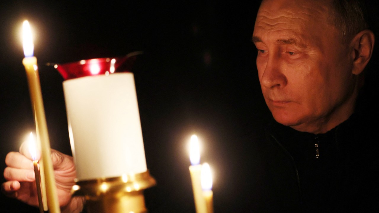 In this pool photograph distributed by the Russian state agency Sputnik, Russia's President Vladimir Putin lights a candle during his visit to a church of the Novo-Ogaryovo state residence outside Moscow on March 24, 2024, during a national day of mourning following the attack in the Crocus City Hall, which has been claimed by the Islamic State (IS) group. Camouflaged assailants opened fire at the packed Crocus City Hall in Moscow's northern suburb of Krasnogorsk on March 22, 2024, ahead of a concert by Soviet-era rock band Piknik in the deadliest attack in Russia for at least a decade. (Photo by Mikhail METZEL / POOL / AFP)