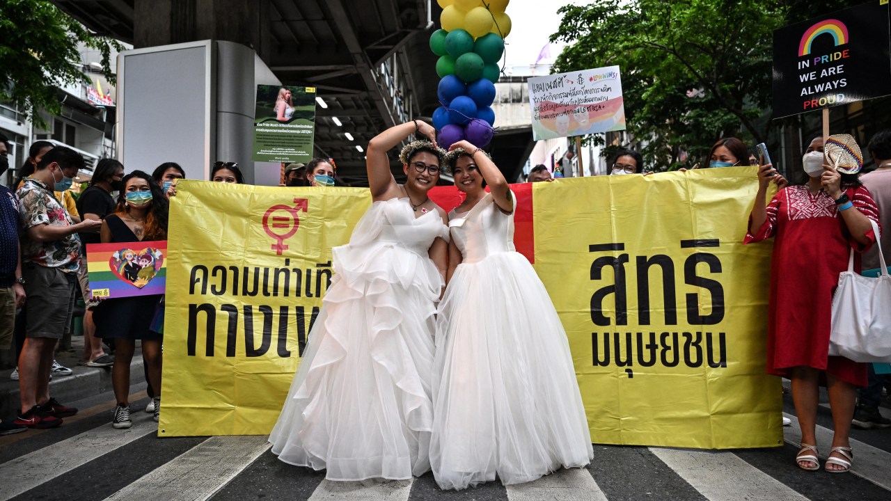 (FILES) A same-sex couple poses in wedding dresses as members of the LGBTQIA+ community take part in a Pride March in Bangkok on June 5, 2022. Thailand's parliament passed a same-sex marriage bill on March 27, 2024, paving the way for the kingdom to become the first Southeast Asian nation to recognise LGBTQ marriage equality. (Photo by Lillian SUWANRUMPHA / AFP)