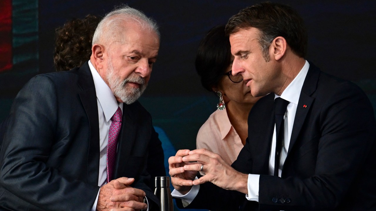 Brazilian President Luiz Inacio Lula da Silva (L) and French President Emmanuel Macron chat during the launch of the Tonelero submarine at the Itaguai naval base in Itaguai, Rio de Janeiro State, Brazil, on March 27, 2024. President Emmanuel Macron told Brazil Wednesday France was "at your side" as the country seeks to develop nuclear-powered submarines, but without announcing specific collaboration on nuclear propulsion technology that Brasilia has pushed for. Macron was speaking during a ceremony to launch Brazil's third French-designed submarine, which will help secure the country's long coastline, dubbed the "Blue Amazon." (Photo by Pablo PORCIUNCULA / AFP)