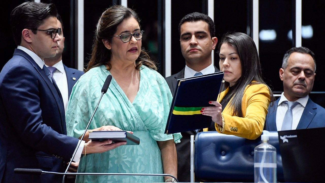 Dra. Eudócia (de vestido azul) em cerimônia de posse no Senado em maio de 2022, observada por seu filho e hoje prefeito de Maceió, João Henrique Caldas (à dir.), o JHC