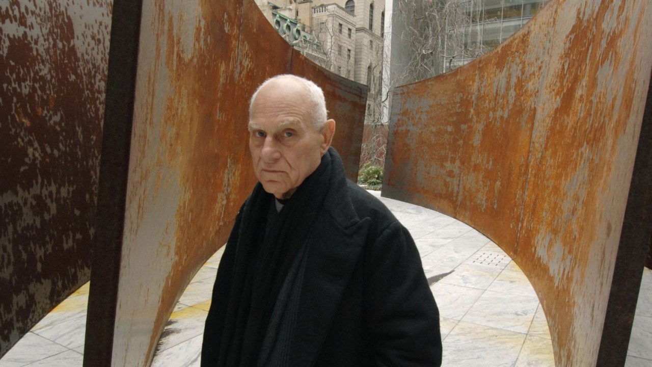 Richard Serra ao lado de uma de suas obras no jardim do Museu de Arte Moderna de Nova York