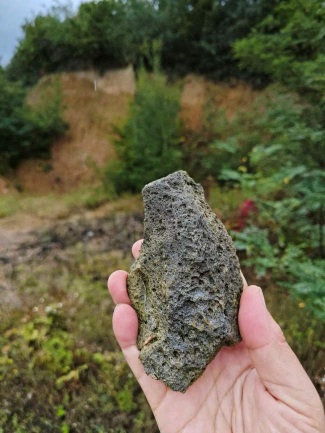 Cientista segura um floco de ferramenta de pedra pré-histórica em Korolevo, no oeste da Ucrânia. 23/08/2023