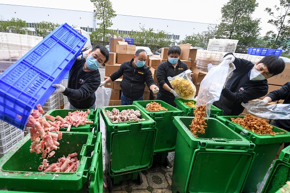 Funcionários de uma empresa de bufê descartando alimentos fora da validade em Changsha, na China. 05/03/2020