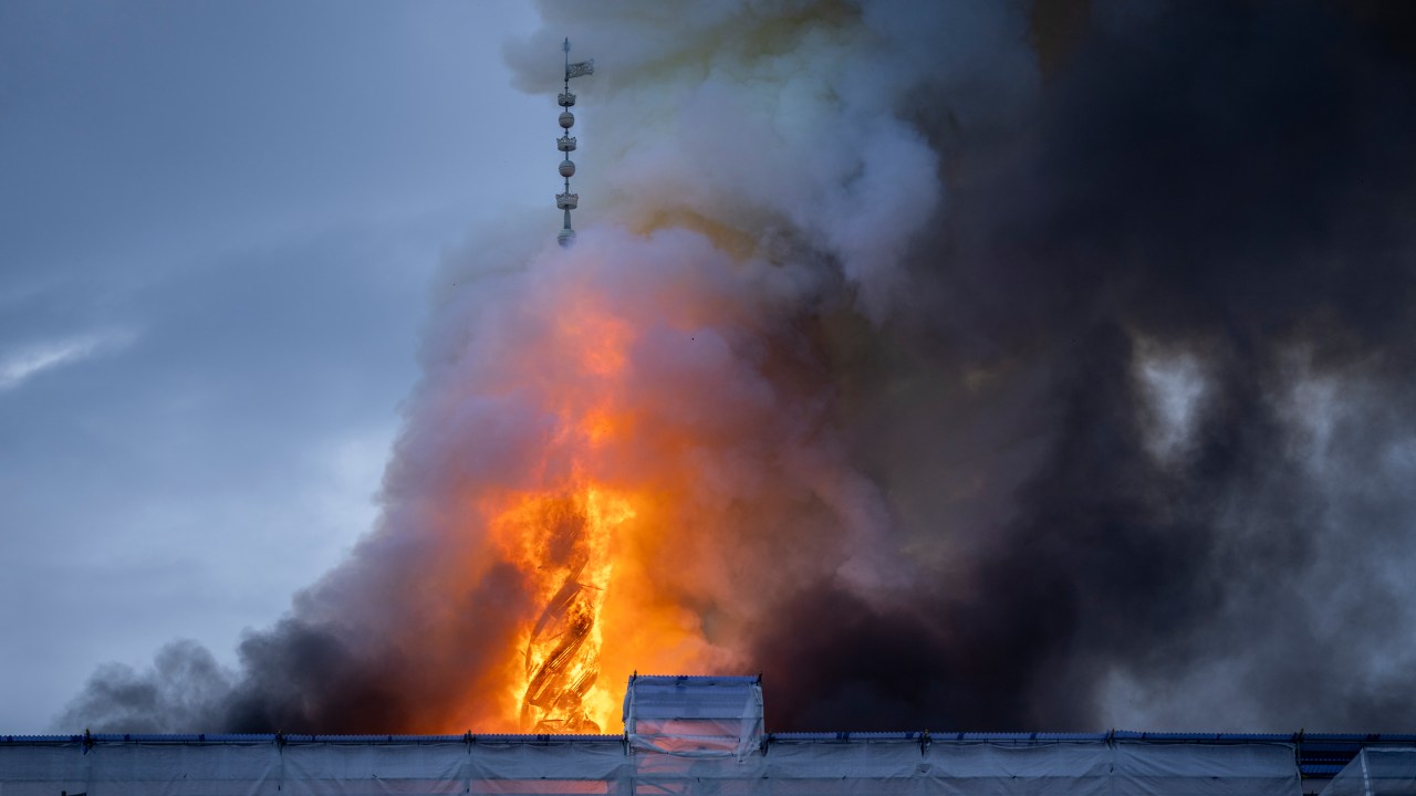The tower of the historic Boersen stock exchange stands in flames as the building is on fire in central Copenhagen, Denmark on April 16, 2024. The building, one of the oldest in the Danish capital, was undergoing renovation work when in the morning it caught fire, whose cause was yet unknown. The building was erected in the 1620s as a commercial building by King Christian IV and is located next to the Danish parliament. (Photo by Ida Marie Odgaard / Ritzau Scanpix / AFP) / Denmark OUT