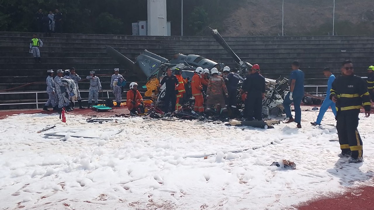 This handout picture taken and released on April 23, 2024 by Perak's Fire and Rescue Department shows rescuers inspecting the crash site after two military helicopters collided in Lumut in Malaysia's Perak state. Two Malaysian military helicopters collided and crashed during a training session on April 23, killing all 10 crew onboard, the country's rescue agency said. (Photo by Handout / Perak's Fire and Rescue Department / AFP) / -----EDITORS NOTE --- RESTRICTED TO EDITORIAL USE - MANDATORY CREDIT "AFP PHOTO / Perak's Fire and Rescue Department " - NO MARKETING - NO ADVERTISING CAMPAIGNS - DISTRIBUTED AS A SERVICE TO CLIENTS -