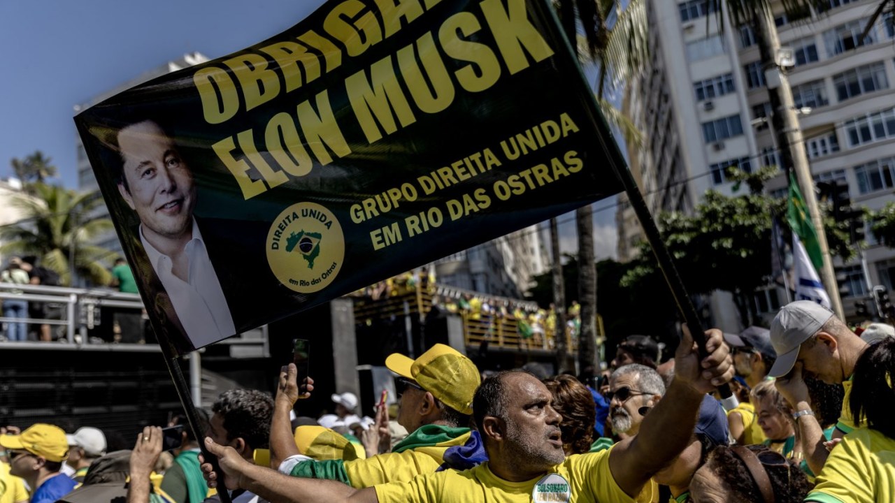 Apoiador de Jair Bolsonaro (PL) levanta bandeira com os dizeres "Obrigado, Elon Musk" durante ato de apoio ao ex-presidente na praia de Copacabana, em 21 de abril de 2024