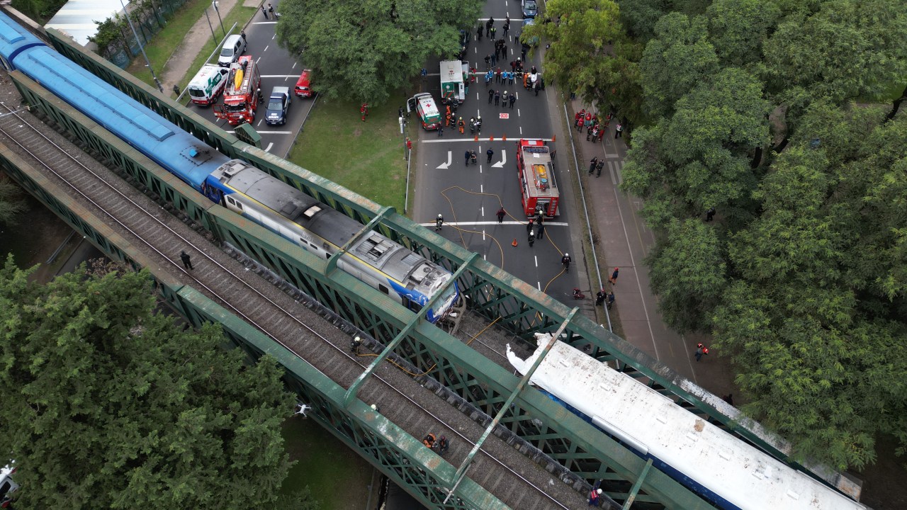 Aerial view of emergency crew members working on a train crash site in Buenos Aires on May 10, 2024. A passenger train crashed into a maintenance train in Buenos Aires on May 10, leaving at least 30 people hospitalized, two of whom were in serious condition, emergency officials said. (Photo by AFP)