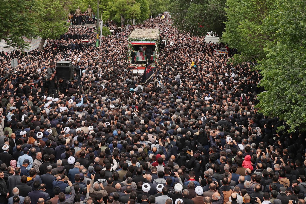 This handout picture provided by the Iranian president's office shows mourners walking in the funeral procession in Tabriz, the capital of Iran's East Azerbaijan province, on May 21, 2024 of late president Ebrahim Raisi and seven others killed with him in a helicopter crash two days ago. Tens of thousands of Iranians gathered in Tabriz on May 21 to mourn Raisi and seven members of his entourage who were killed in the crash on a fog-shrouded mountainside in northwestern Iran. (Photo by Iranian Presidency / AFP) / === RESTRICTED TO EDITORIAL USE - MANDATORY CREDIT "AFP PHOTO / HO / IRANIAN PRESIDENCY" - NO MARKETING NO ADVERTISING CAMPAIGNS - DISTRIBUTED AS A SERVICE TO CLIENTS ===