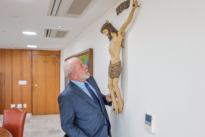 O presidente Luiz Inácio Lula da Silva observa imagem de Jesus Cristo crucificado no seu gabinete no Palácio do Planalto, em julho do ano passado