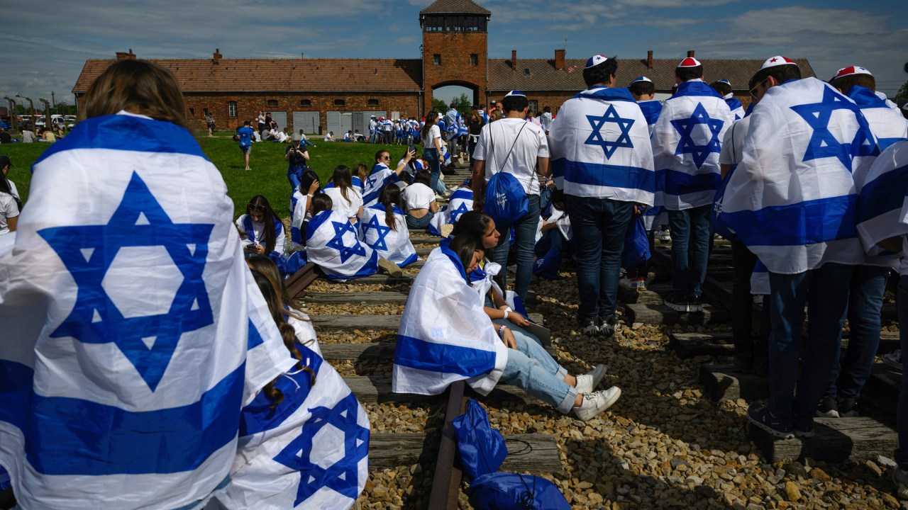 Um grupo de participantes da Marcha dos Vivos recita as orações nos trilhos do trem após entrar em Birkenau e marchar de Auschwitz, na Polônia. 06/05/2024
