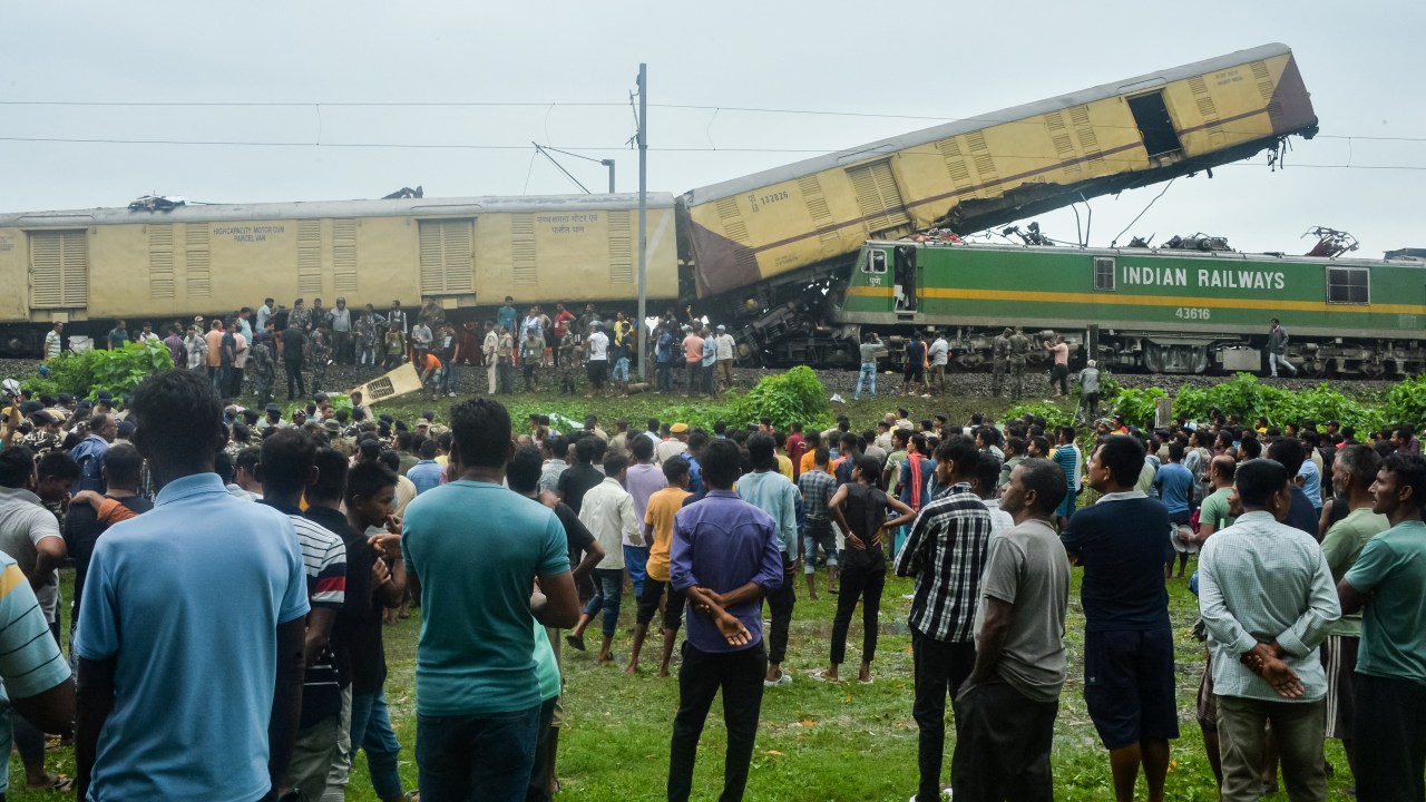 Pessoas reunidas após a colisão entre o Expresso Kanchenjungha e um trem de carga perto da estação ferroviária de Rangapani, na Índia.