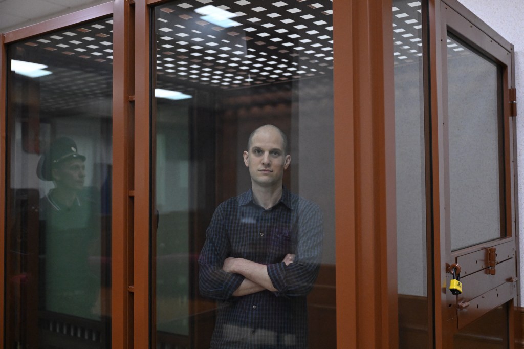 US journalist Evan Gershkovich, accused of espionage, looks out from inside a glass defendants' cage prior to a hearing in Yekaterinburg's Sverdlovsk Regional Court on June 26, 2024. (Photo by NATALIA KOLESNIKOVA / AFP)