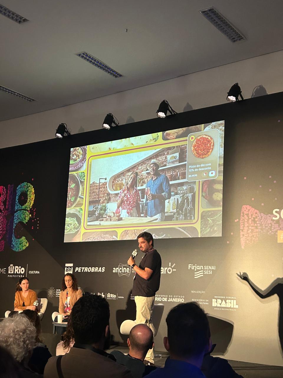 Apresentação da Globo no Rio2C com ícone para comprar uma pizza no canto da tela