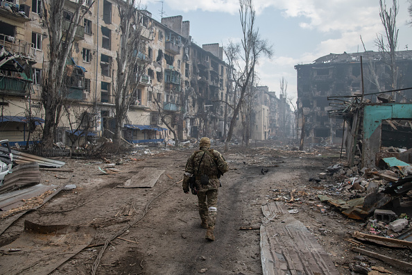 Soldado russo caminhando entre destroços após ataque à cidade ucraniana de Mariupol. 15/04/2024