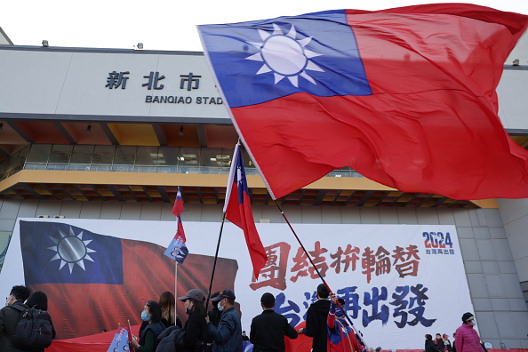 Pessoas segurando a bandeira de Taiwan durante uma campanha eleitoral em Nova Taipé. 12/01/2024