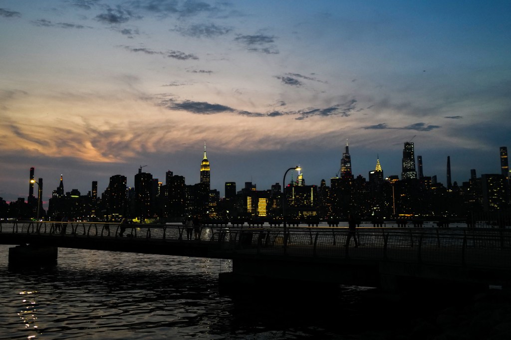 New York city's midtown Manhattan skyline, with the Empire State building (C-L), is seen at dusk from the Brooklyn Borough of New York on July 15, 2024. (Photo by CHARLY TRIBALLEAU / AFP)