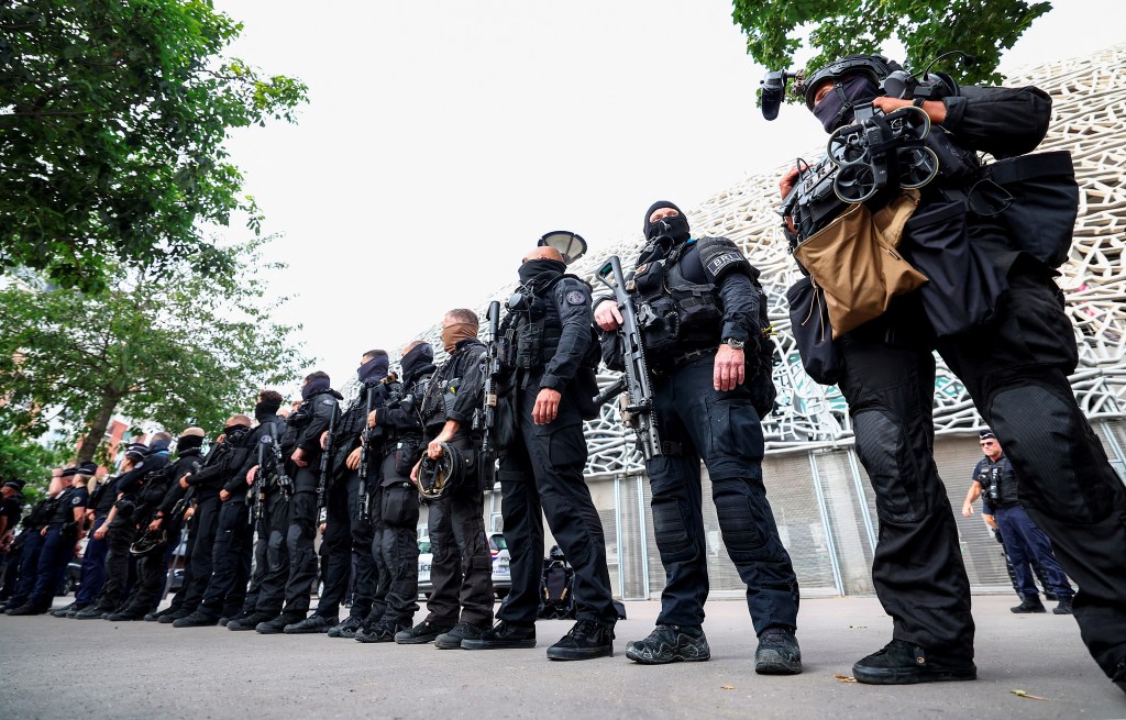 Members of the French Brigade de Recherche et d'Intervention (BRI - Research and Intervention Brigade) police unit stand guard in front of the stadium before the start of the men's group D football match between Mali and Israel during the Paris 2024 Olympic Games at the Parc des Princes in Paris on July 24, 2024. (Photo by FRANCK FIFE / AFP)