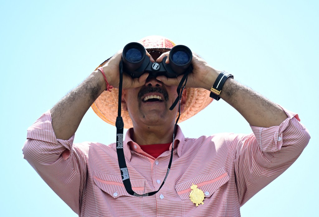 Venezuelan President and presidential candidate Nicolas Maduro looks through binoculars during his campaign closing rally in Maracaibo, Zulia State, Venezuela, on July 25, 2024, ahead of Sunday's presidential election. Venezuelan President Nicolas Maduro and his main rival in the July 28 presidential elections, opposition candidate Edmundo Gonzalez Urrutia, close their campaigns on Thursday amidst Maduro's warnings of a "bloodbath" or a military insurrection if he is defeated. (Photo by Raul ARBOLEDA / AFP)