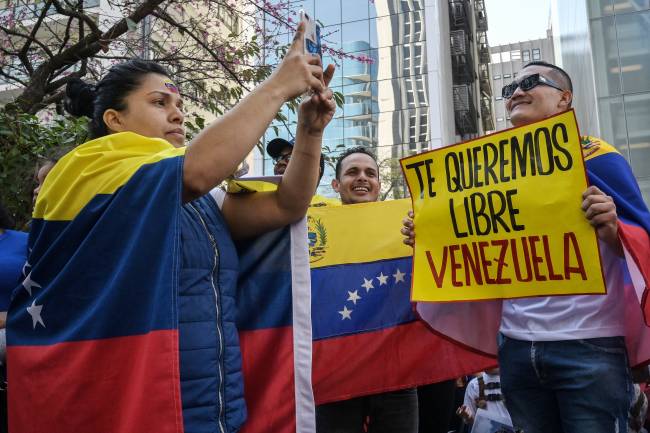 A Venezuelan citizen holds a banner that reads in spanish 'We want you free Venezuela' during a protest in support of the Venezuelan opposition at Paulista Avenue in Sao Paulo, Brazil, on July 28, 2024. Venezuelans vote Sunday between continuity in President Nicolas Maduro or change in rival Edmundo Gonzalez Urrutia amid high tension following the incumbent's threat of a 