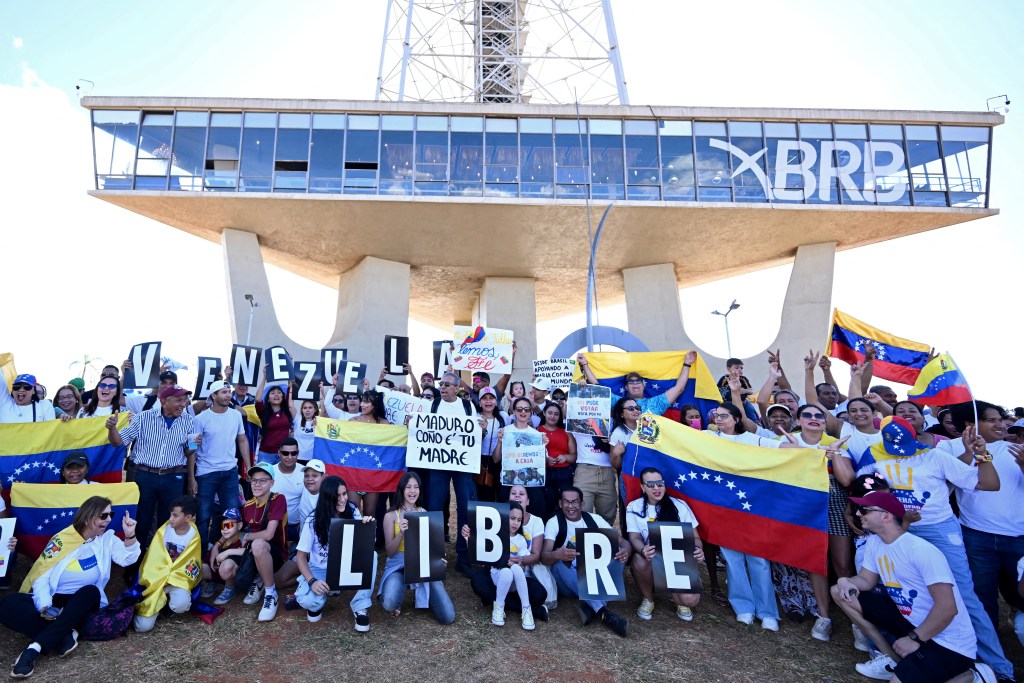 Venezuelan citizens take part in a protest in support of the Venezuelan opposition in Brasília, Brazil, on July 28, 2024. Venezuelans vote Sunday between continuity in President Nicolas Maduro or change in rival Edmundo Gonzalez Urrutia amid high tension following the incumbent's threat of a "bloodbath" if he loses. (Photo by EVARISTO SA / AFP)