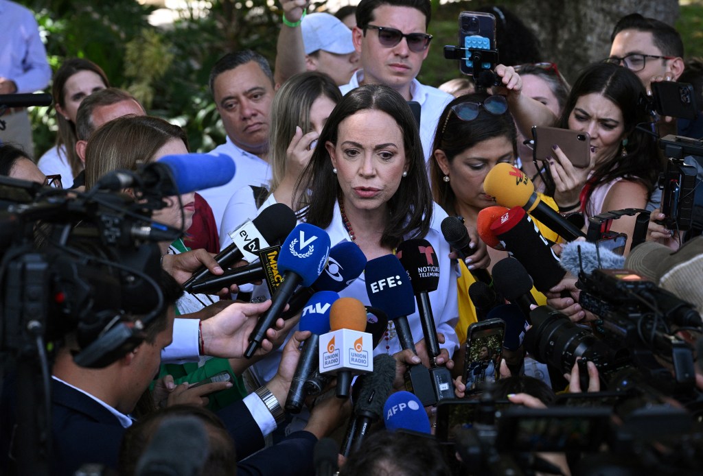 Venezuelan opposition leader Maria Corina Machado speaks with the media after casting her vote during the presidential election, in Caracas on July 28, 2024. Venezuelans vote Sunday between continuity in President Nicolas Maduro or change in rival Edmundo Gonzalez Urrutia amid high tension following the incumbent's threat of a "bloodbath" if he loses, which polls suggest is likely. (Photo by Federico PARRA / AFP)