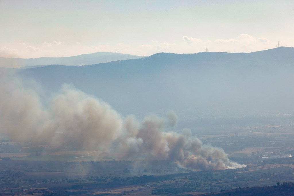 Smoke billows after a hit from a rocket fired from southern Lebanon over the Upper Galilee region in northern Israel on July 30, 2024, amid ongoing cross-border clashes between Israeli troops and Hezbollah fighters. Israeli medics on July 30 said one civilian, a 30-year-old man, was killed following a rocket attack on the northern kibbutz of HaGoshrim. The Israeli army meanwhile reported its forces were "striking the sources of fire" after the projectiles were fired from Lebanon. (Photo by Jalaa MAREY / AFP)