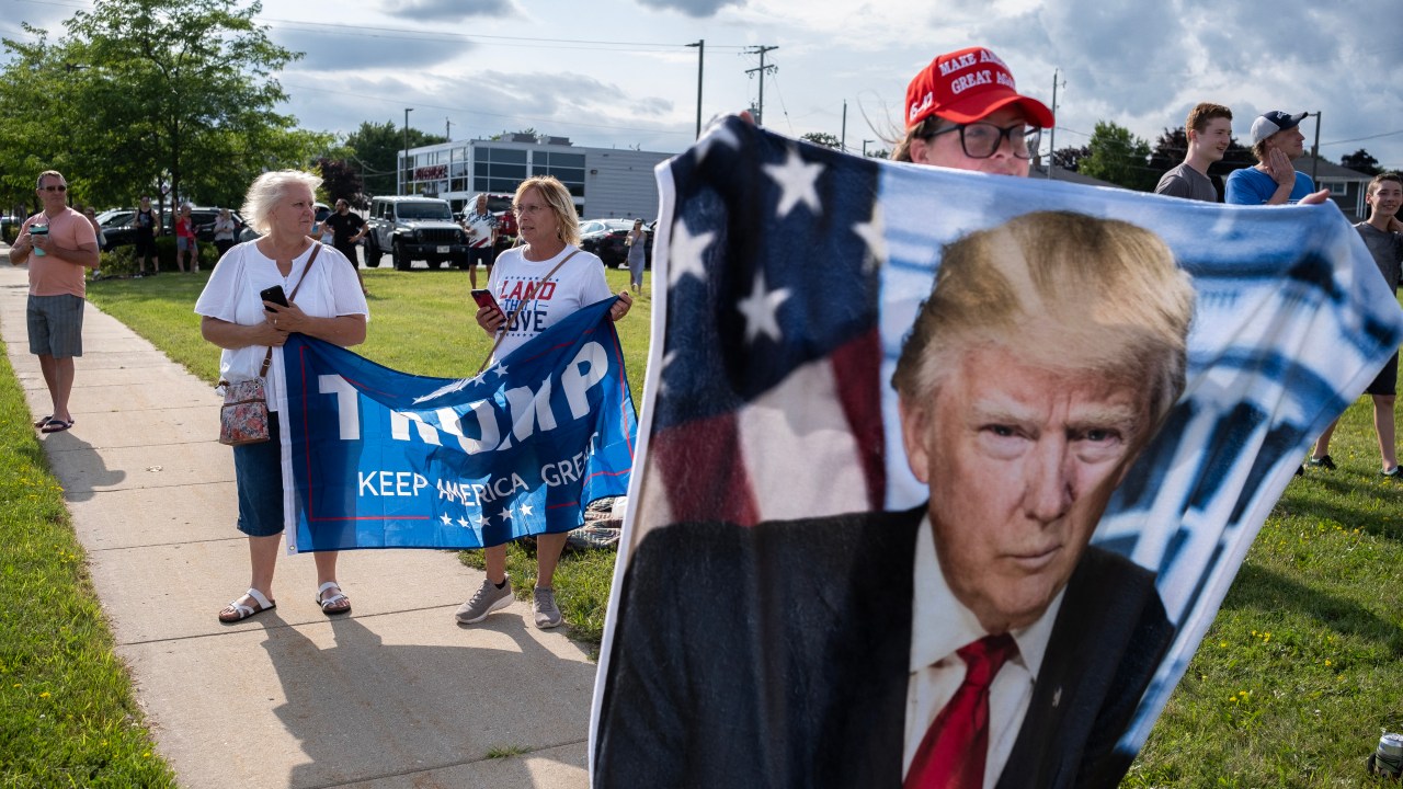 MILWAUKEE, WISCONSIN - JULY 14: Supporters of Republican presidential candidate, former U.S. President Donald await his arrival at Milwaukee Mitchell International Airport on July 14, 2024 in Milwaukee, Wisconsin. Law enforcement officials began final preparations on the eve of the Republican National Convention where Trump is expected to formally receive the GOP nomination for the 2024 U.S. Presidential election. Trump suffered minor injuries during a campaign rally on on July 13 in Butler, Pennsylvania after a gunman opened fired, killing one person and injuring two critically. Jim Vondruska/Getty Images/AFP (Photo by Jim Vondruska / GETTY IMAGES NORTH AMERICA / Getty Images via AFP)