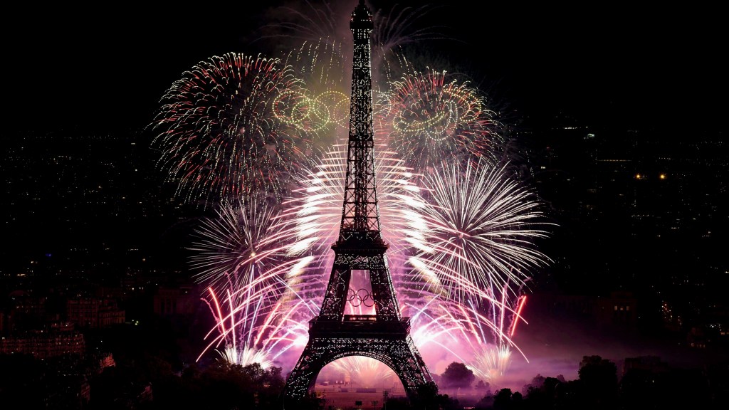 É UMA FESTA - Fogos na Torre Eiffel para celebrar o 14 de Julho: os anéis olímpicos dão o clima na cidade