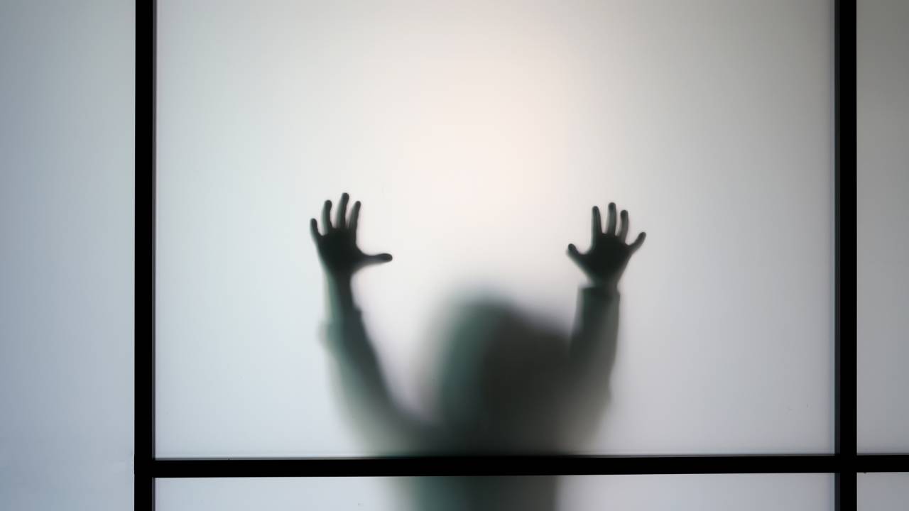 Mãos de criança tocando vidro: cresce número de vídeos falsos de abuso sexual de crianças na internet -
