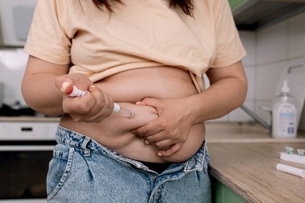 Injections for weight loss with Semaglutide. An obese woman gives a hormonal injection into the abdomen with a pen syringe. USO SEMANAL - Wegovy e Mounjaro: doença crônica exige terapia contínua