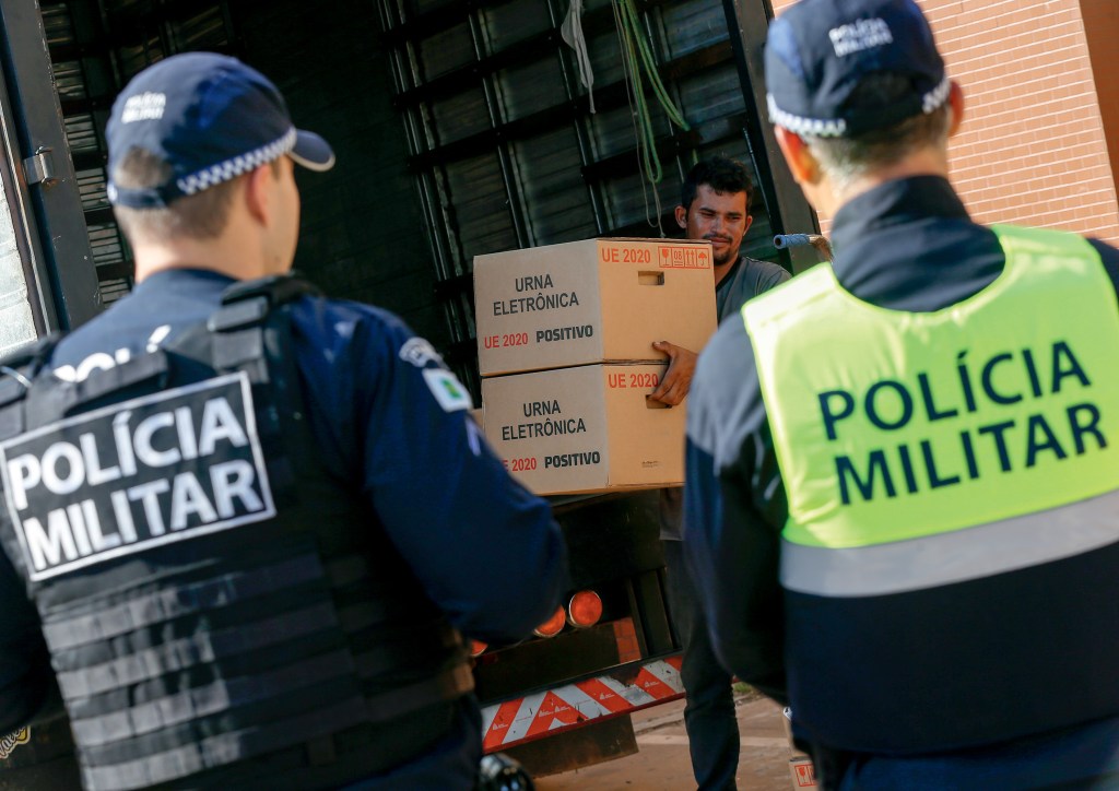ESCOLTA - Urna chega a local de votação em área dominada pelo crime organizado: democracia na mira