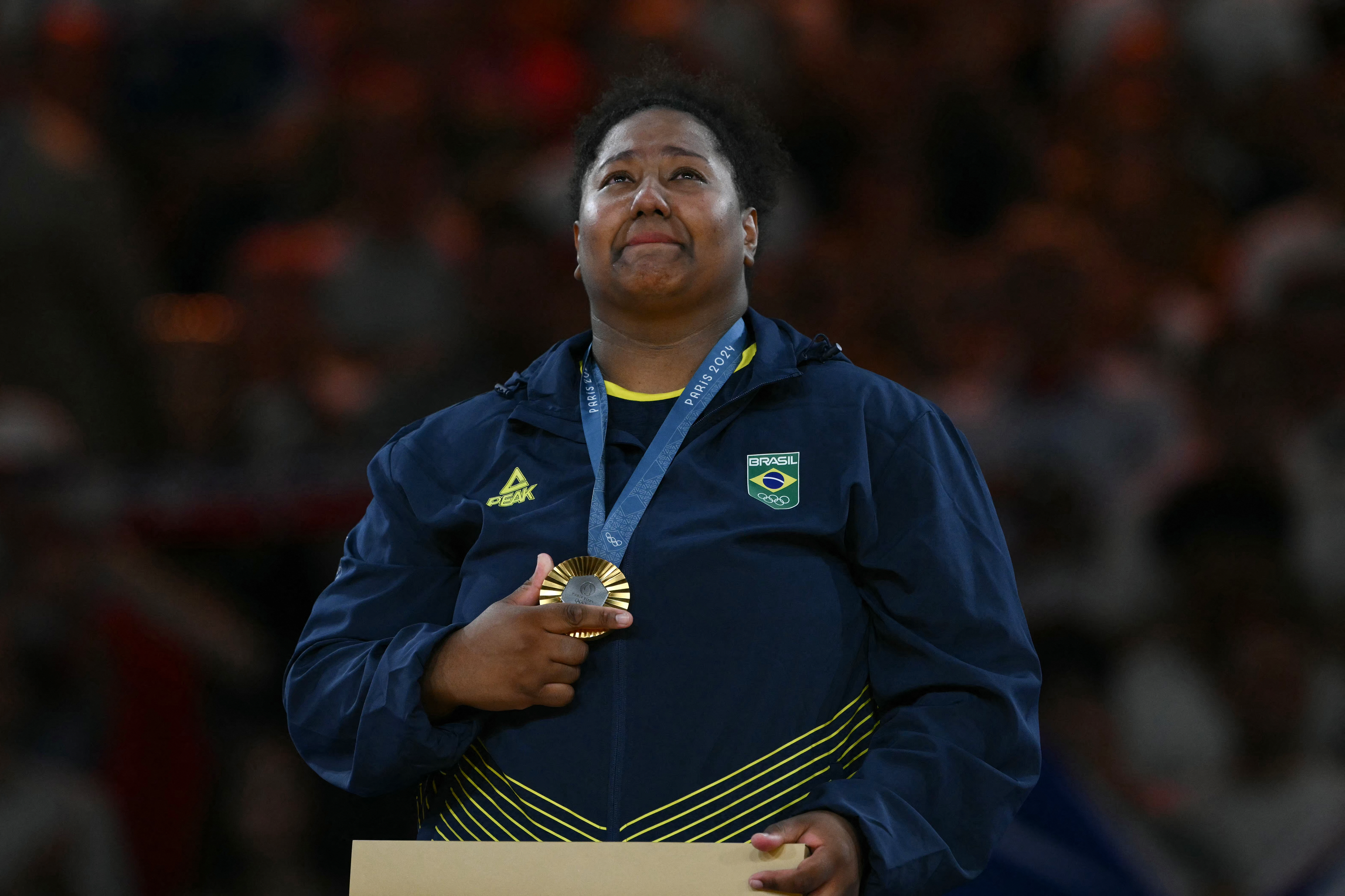 Gold medallist Brazil's Beatriz Souza celebrates on the podium after the judo women's +78kg gold medal bout of the Paris 2024 Olympic Games at the Champ-de-Mars Arena, in Paris on August 2, 2024. (Photo by Luis ROBAYO / AFP)