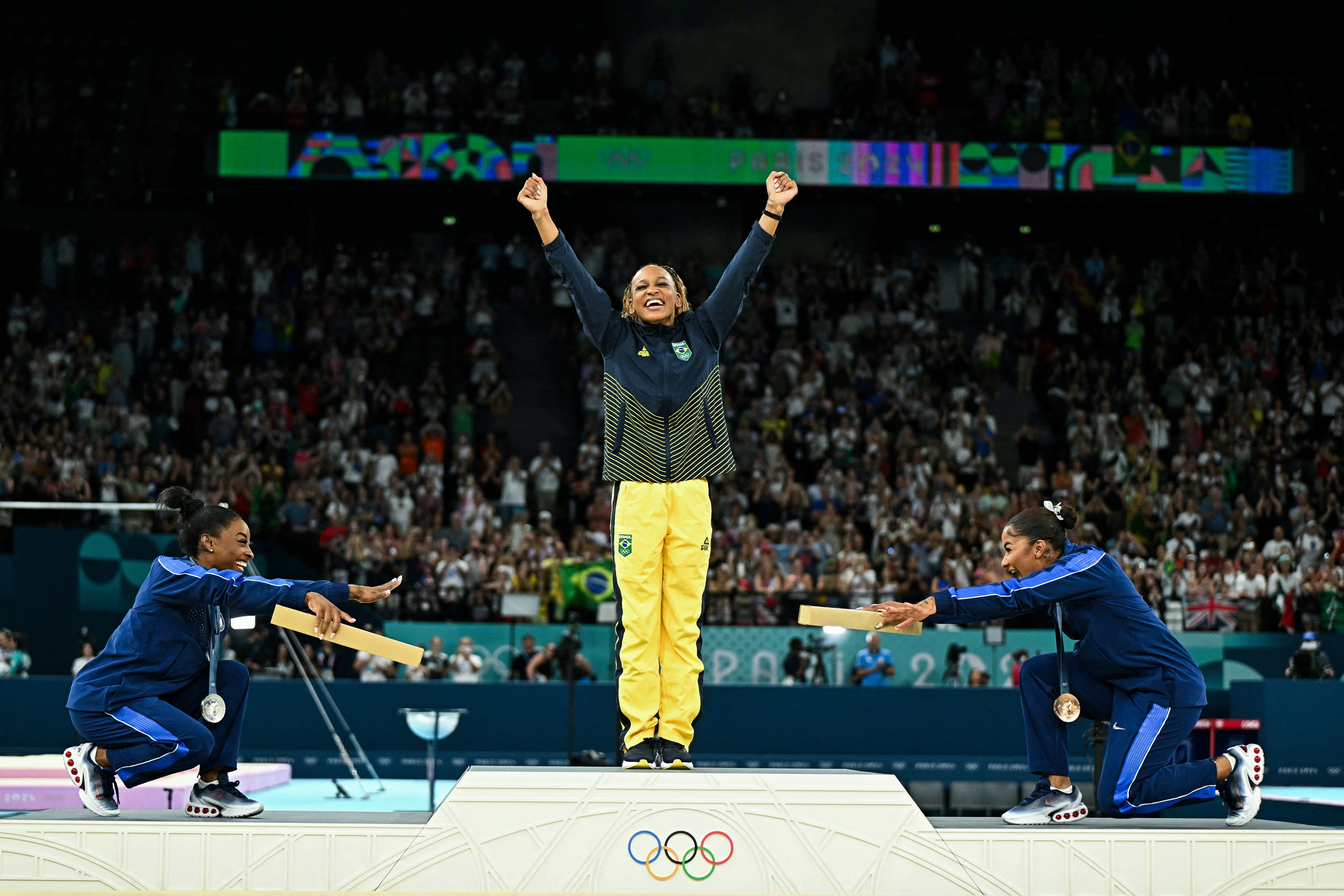 (LtoR) US' Simone Biles (silver), Brazil's Rebeca Andrade (gold) and US' Jordan Chiles (bronze) pose during the podium ceremony for the artistic gymnastics women's floor exercise event of the Paris 2024 Olympic Games at the Bercy Arena in Paris, on August 5, 2024. (Photo by Gabriel BOUYS / AFP)