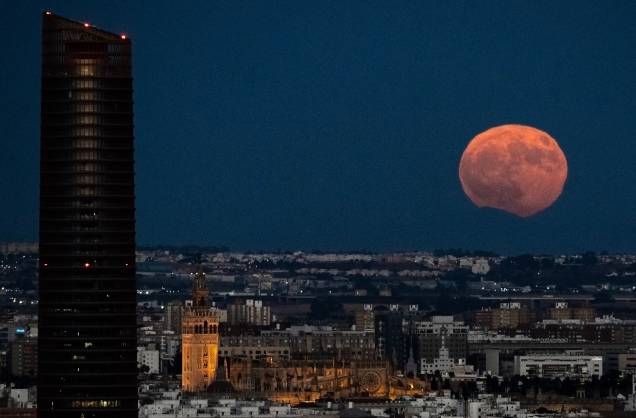 A imagem mostra a Torre Pelli e a catedral enquanto a Lua cheia nasce sobre Sevilha, na Espanha A imagem mostra a Torre Pelli e a catedral enquanto a Lua cheia nasce sobre Sevilha, na Espanha